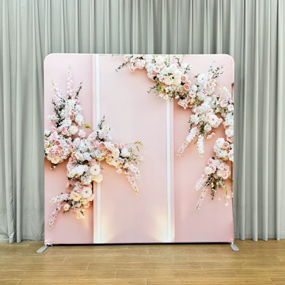 Soft pink backdrop with cascading white and pink floral arrangements