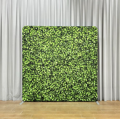Lush green boxwood hedge photo booth backdrop